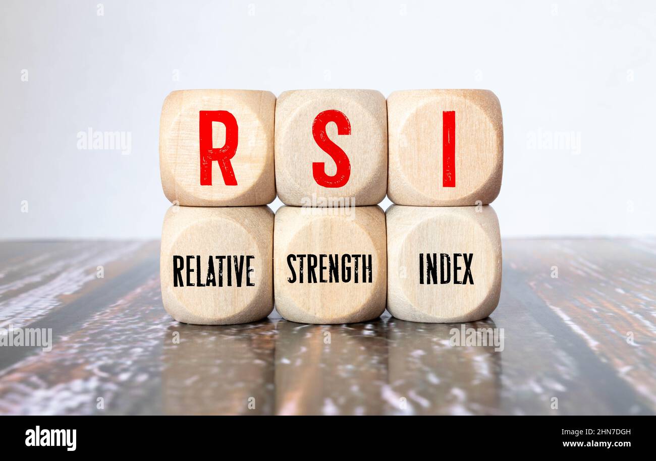 RSI - Relative Strength Index acronym concept on cubes, gray background. Reflection on the mirrored surface of the table. Selective focus. Stock Photo