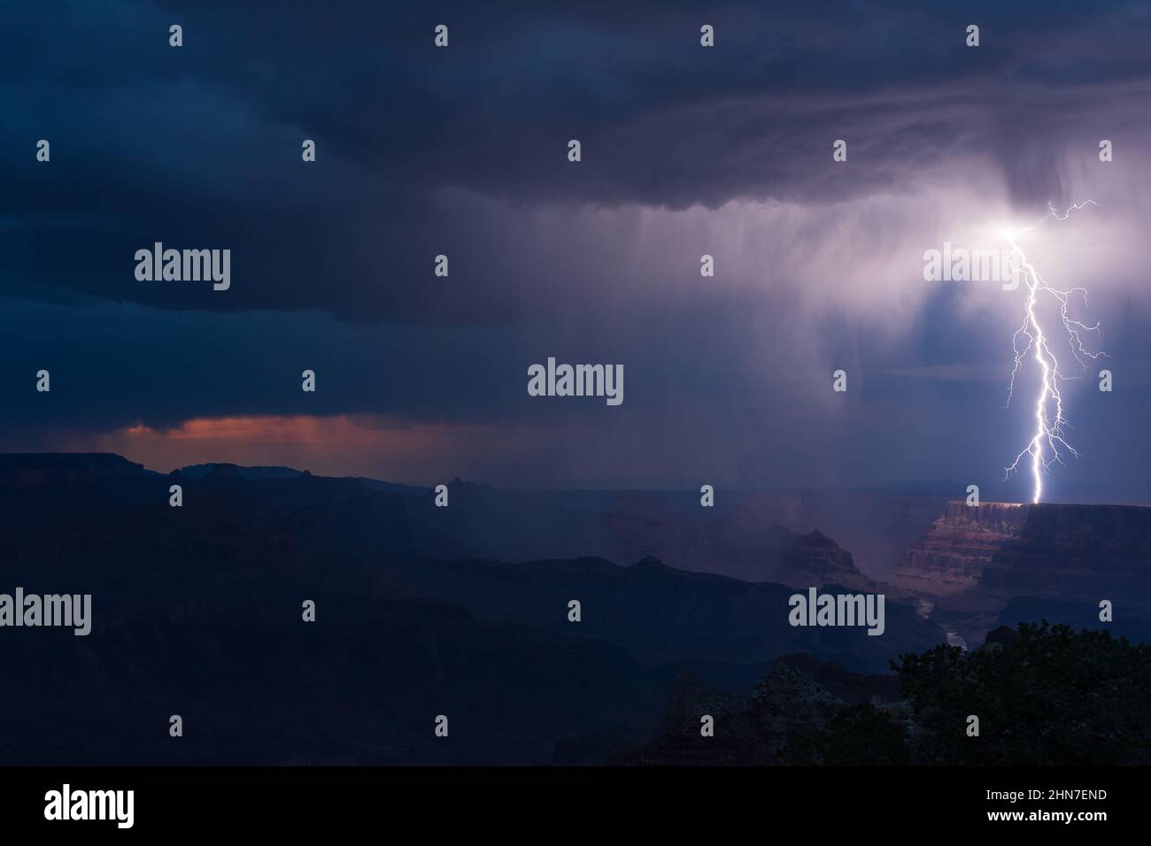 A dramatic lightning bolt illuminates the Colorado River as a thunderstorm passes through the Grand Canyon Stock Photo