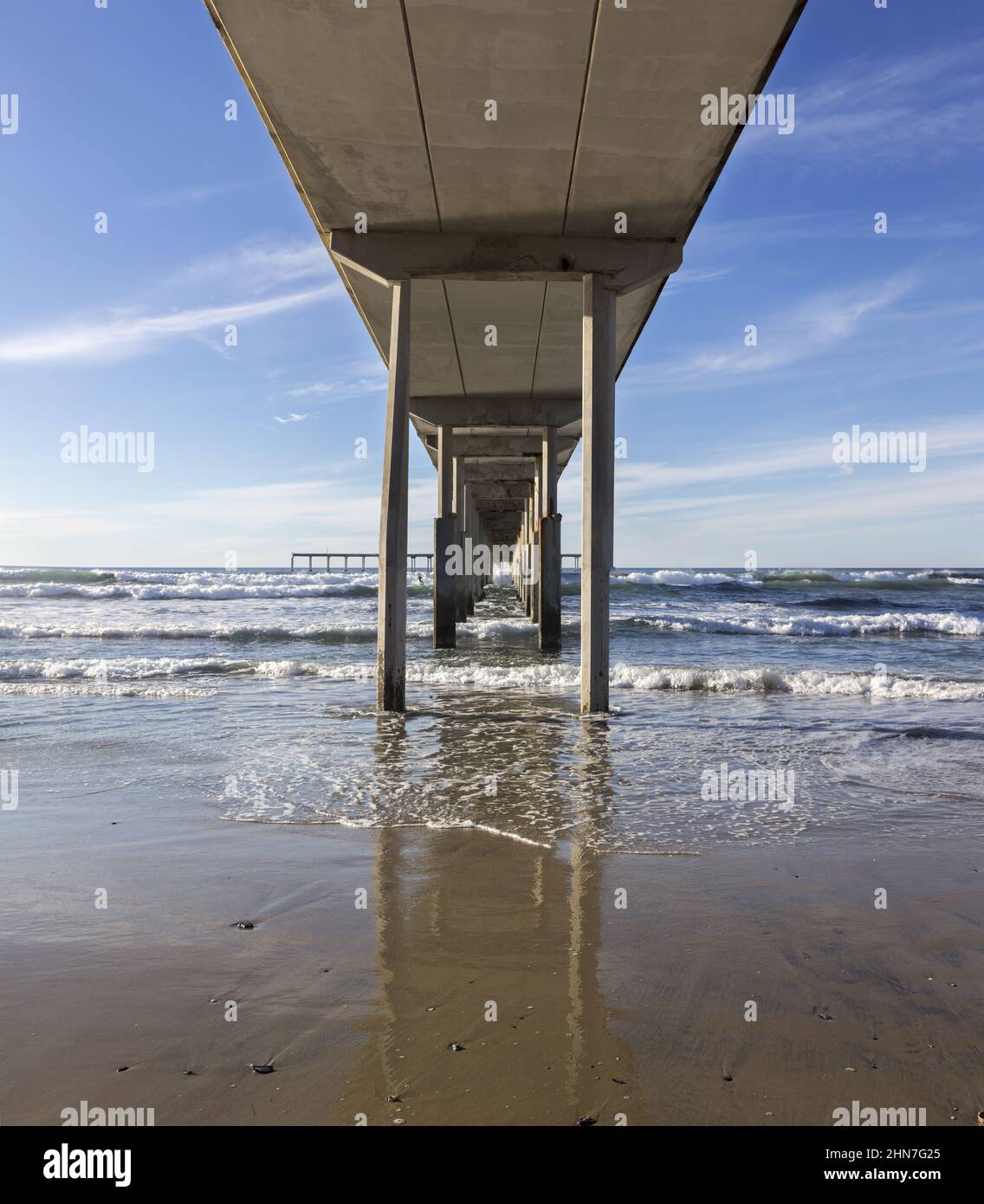 Water Level View Under Ocean Beach Pier Wooden Structure. San Diego California Pacific Coast Scenic Detail on a Clear Sunny Winter Day Stock Photo