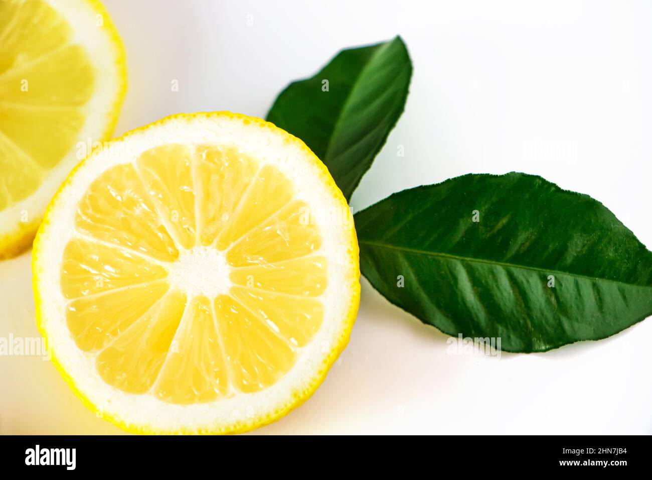 Fresh juicy lemon slices on white background. Citrus fruit high in vitamin C. Antioxidant for healthy diet. Stock Photo