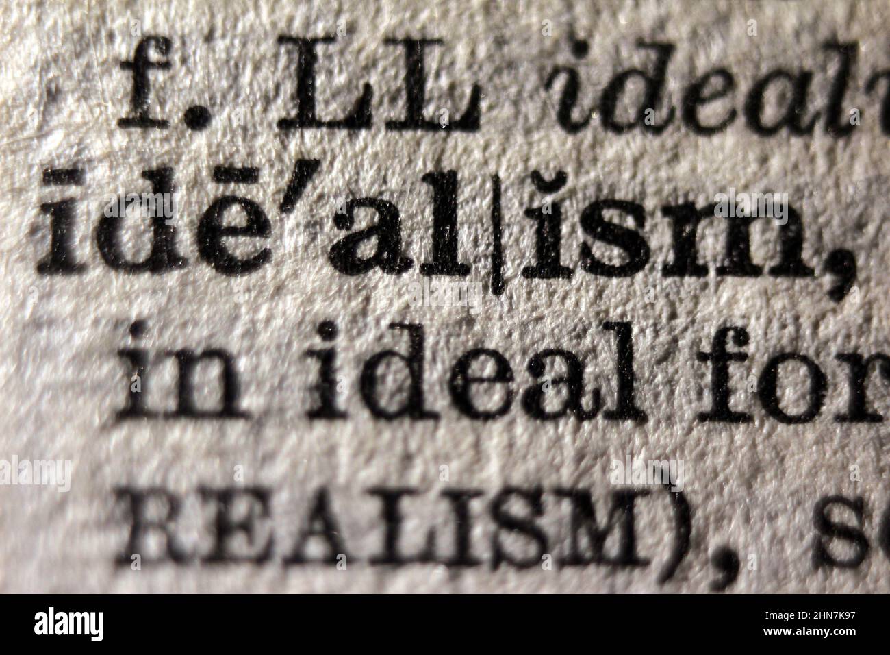 Word "idealism" printed on dictionary page, macro close-up Stock Photo
