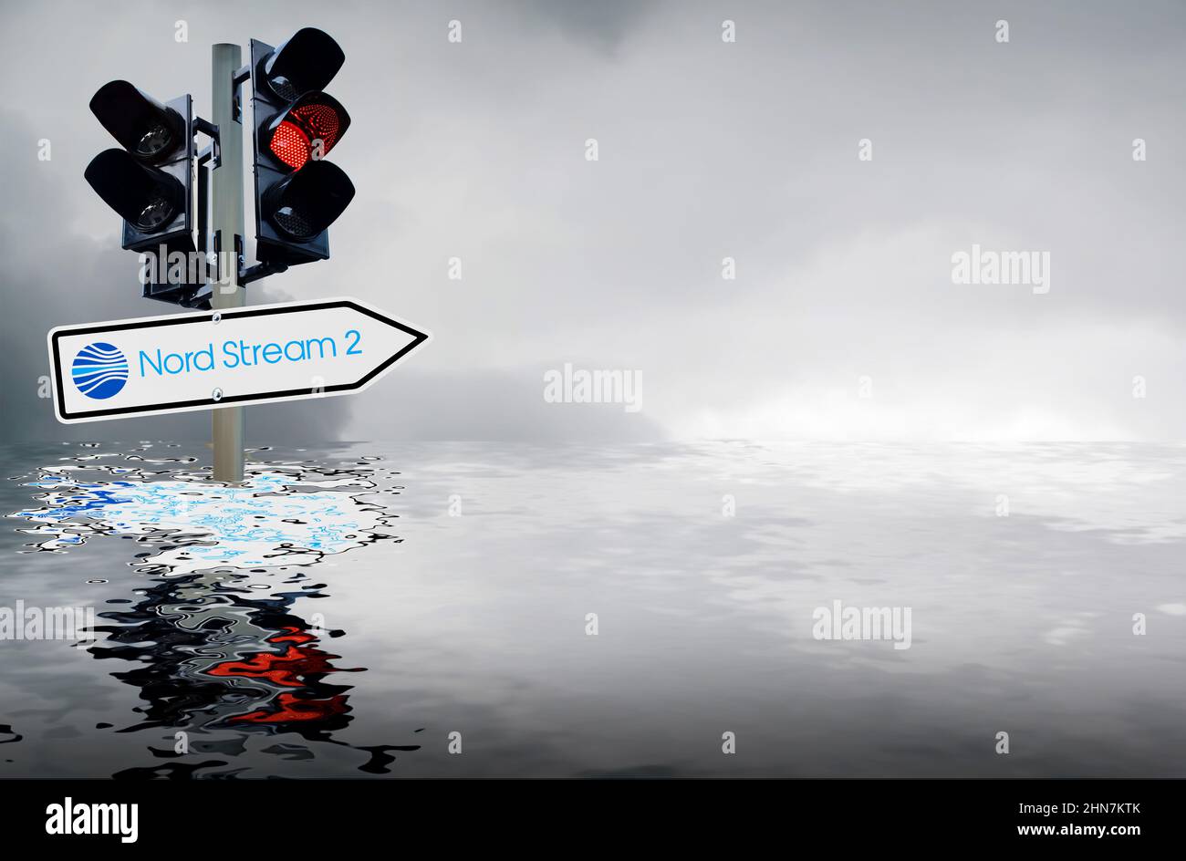 Symbolic image Nord Stream 2: Traffic light with traffic sign and grey sky reflected in the sea Stock Photo