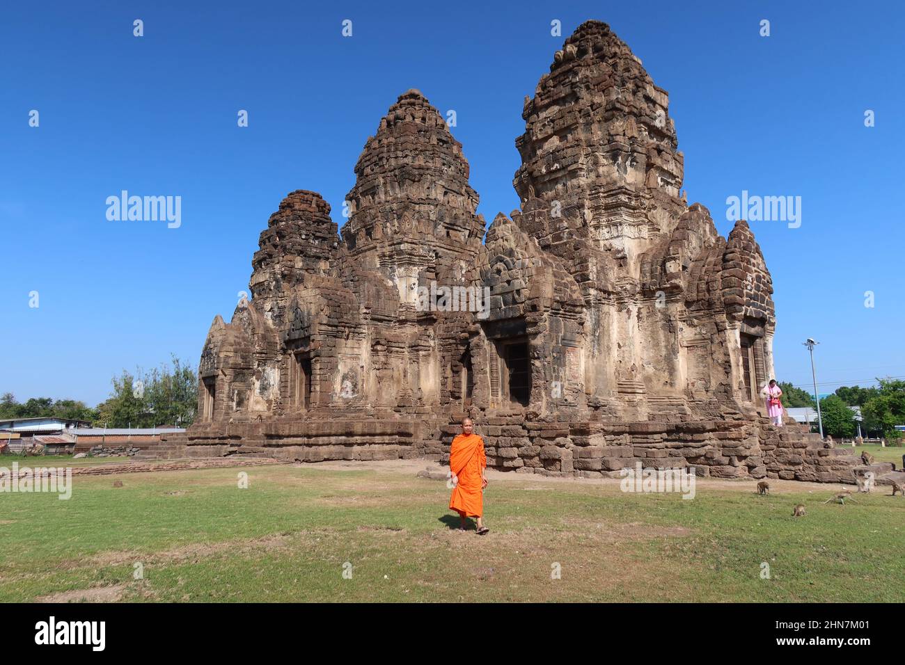 Monk walking in the historic Khmer-style Wat Phra Phang San Yot, the Monkey Temple, Lopburi, Thailand Stock Photo