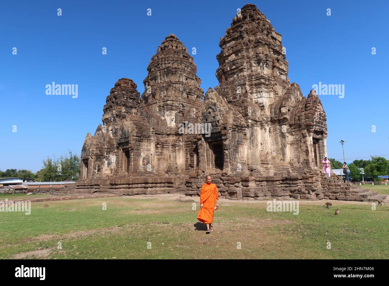 Buddhist Monk walking in the historic Khmer-style Wat Phra Phang San Yot, the Monkey Temple, Lopburi, Thailand Stock Photo