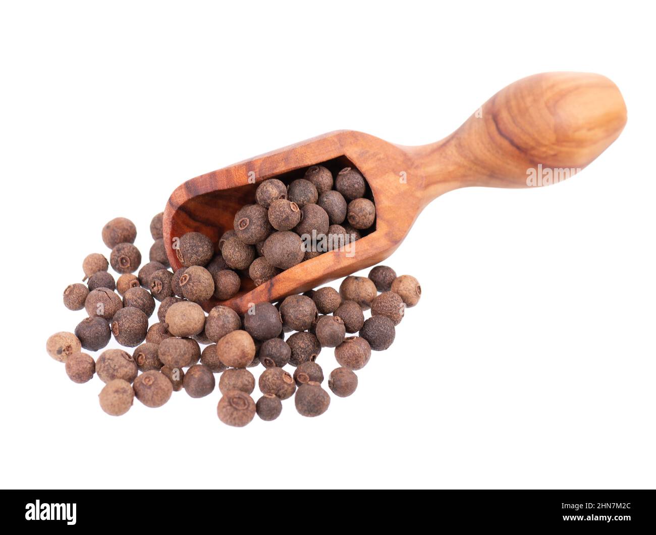 Allspice in wooden scoop, isolated on white background. Jamaican pepper