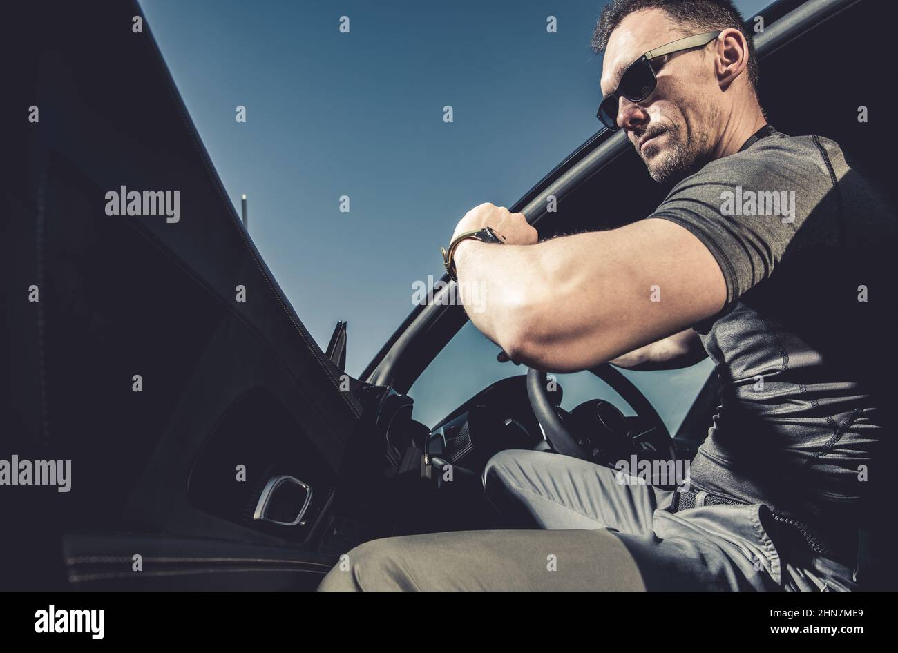 Caucasian Male in His 40s Looking at His Hand Watch While Leaving His Sporty Car. Being on Time Concept. Stock Photo