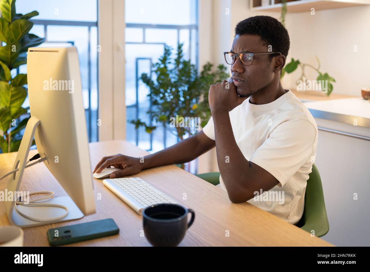Thoughtful web developer work on computer, programmer trying to find solution for bug in app code Stock Photo
