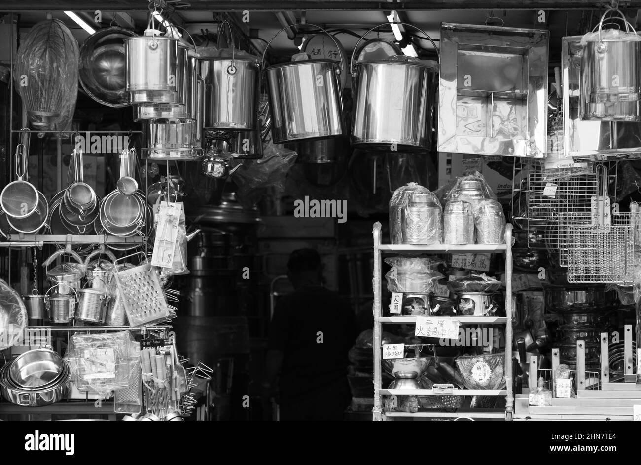 Shiny metal pots, pans and kitchen utensils for sale in a Hong Kong shop Stock Photo