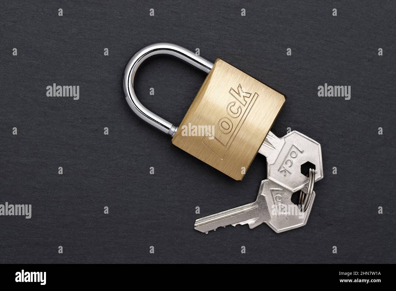 Steel padlock with key on a black background Stock Photo - Alamy
