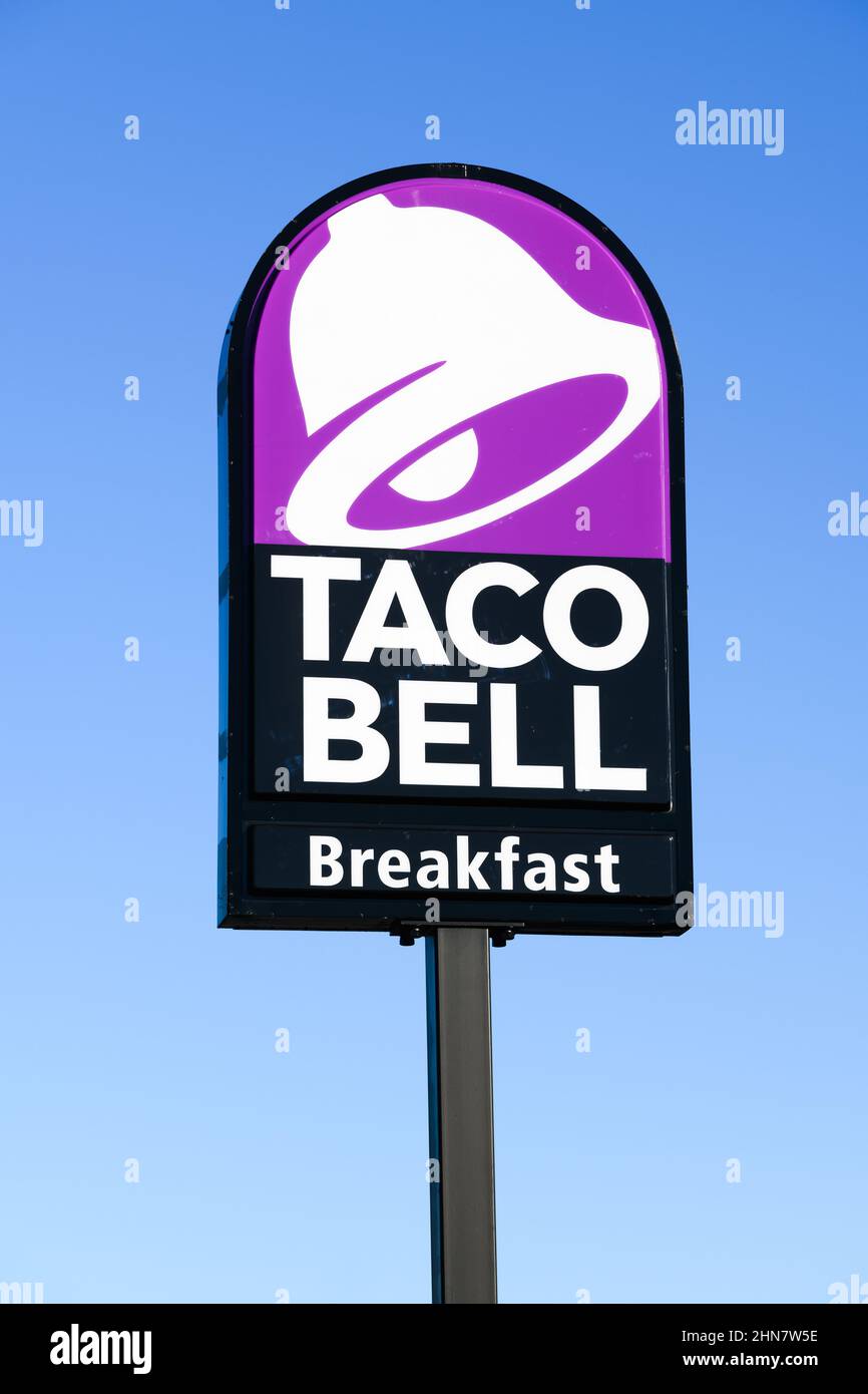 Burlington, WA, USA - February 12, 2022; Taco Bell purple sign advertising breakfast on roadside signpost against a blue sky Stock Photo