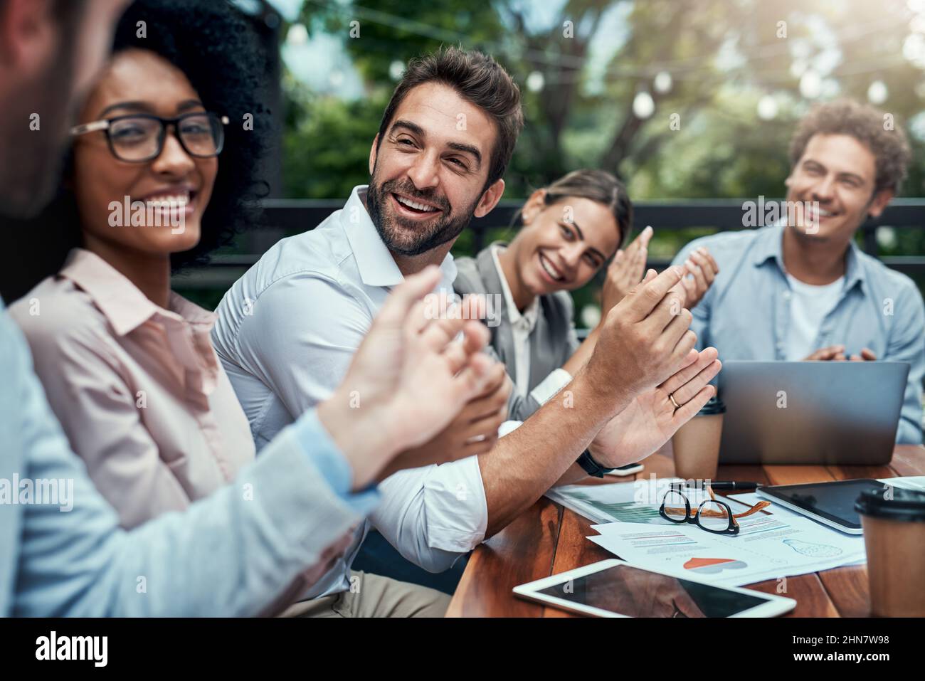 Seeing their success all come together. Shot of a group of colleagues applauding during a meeting at a cafe. Stock Photo