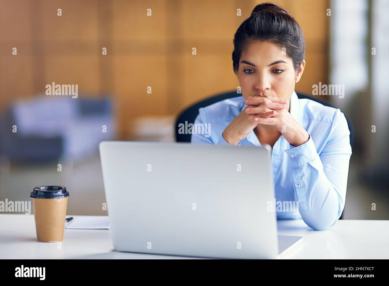The deadline is looming.... Shot of a young businesswoman looking stressed while working at her desk. Stock Photo