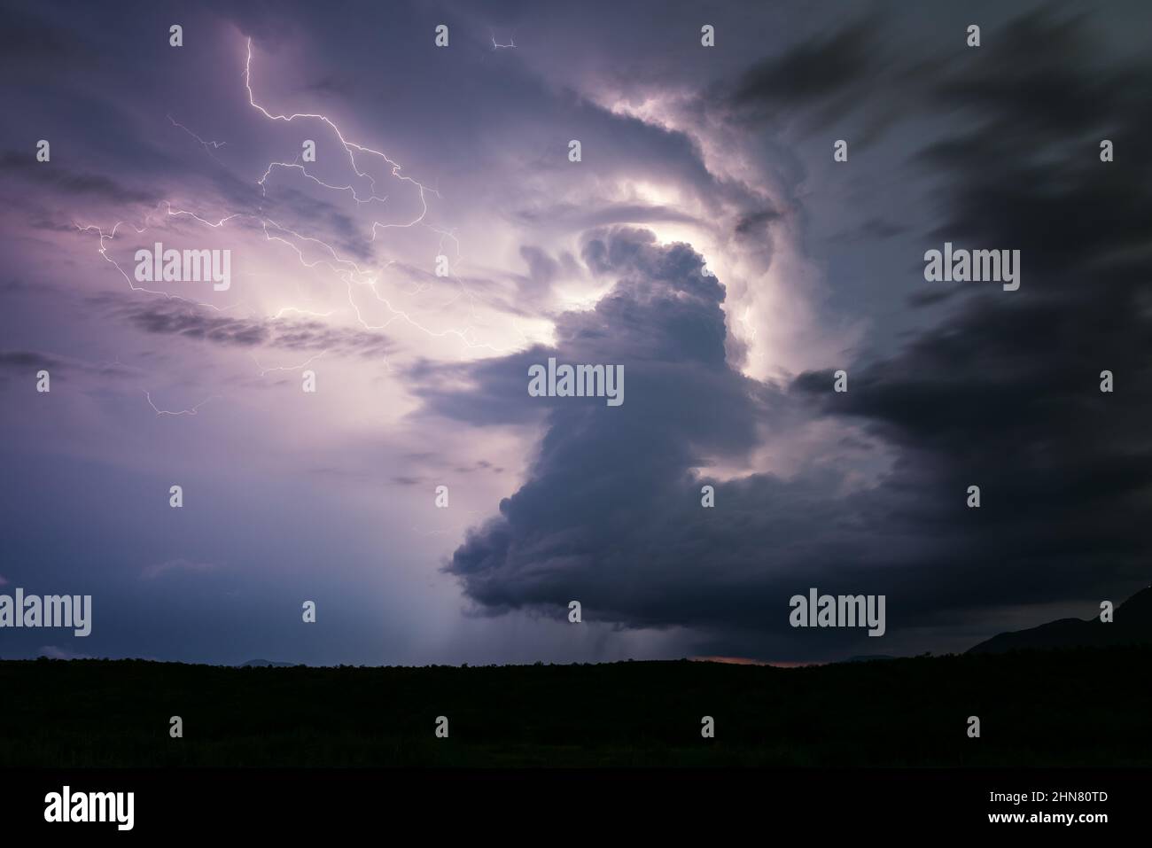 Lightning illuminates a supercell thunderstorm cumulonimbus cloud near Camp Verde, Arizona Stock Photo