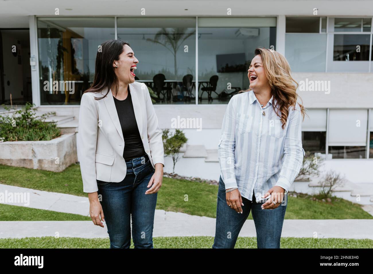 two latin women friends hugging at terrace office in Mexico Latin America Stock Photo