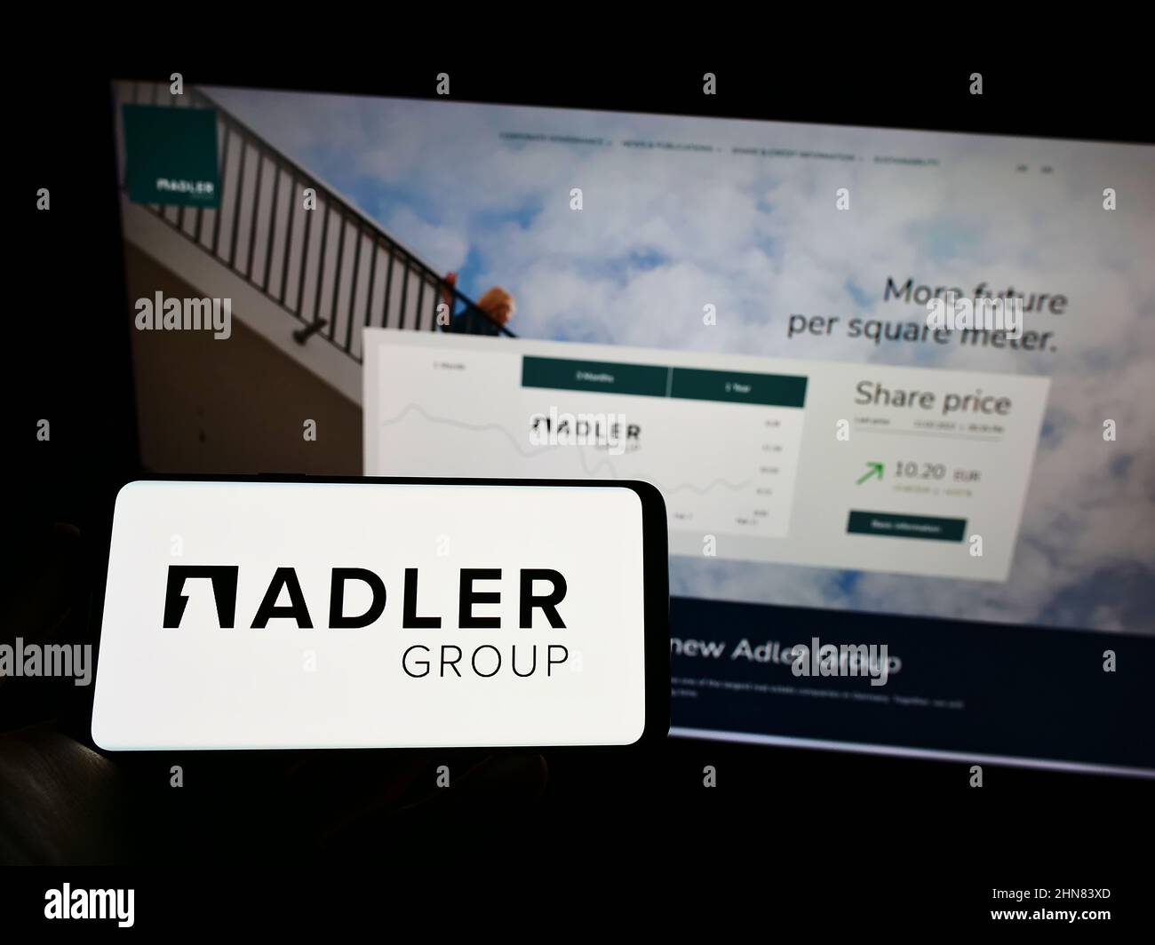 Person holding cellphone with logo of real estate company Adler Group S