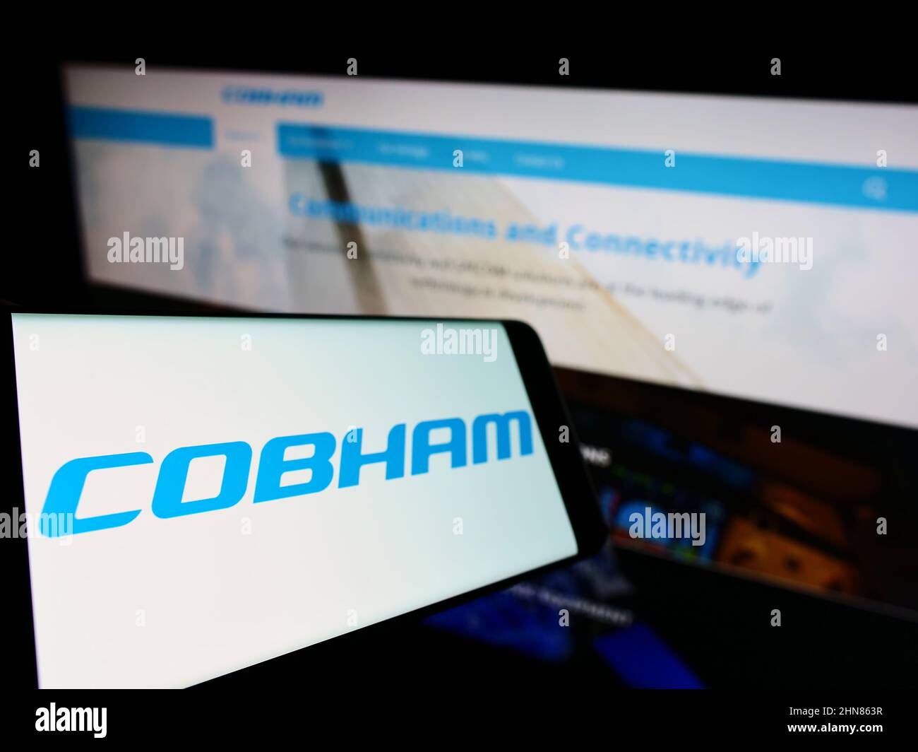 Smartphone with logo of British aerospace company Cobham Limited on screen in front of business website. Focus on left of phone display. Stock Photo