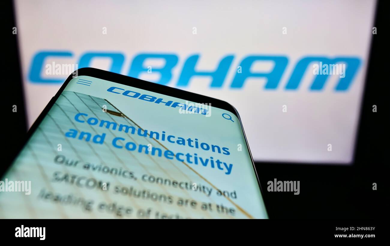 Mobile phone with webpage of British aerospace company Cobham Limited on screen in front of business logo. Focus on top-left of phone display. Stock Photo