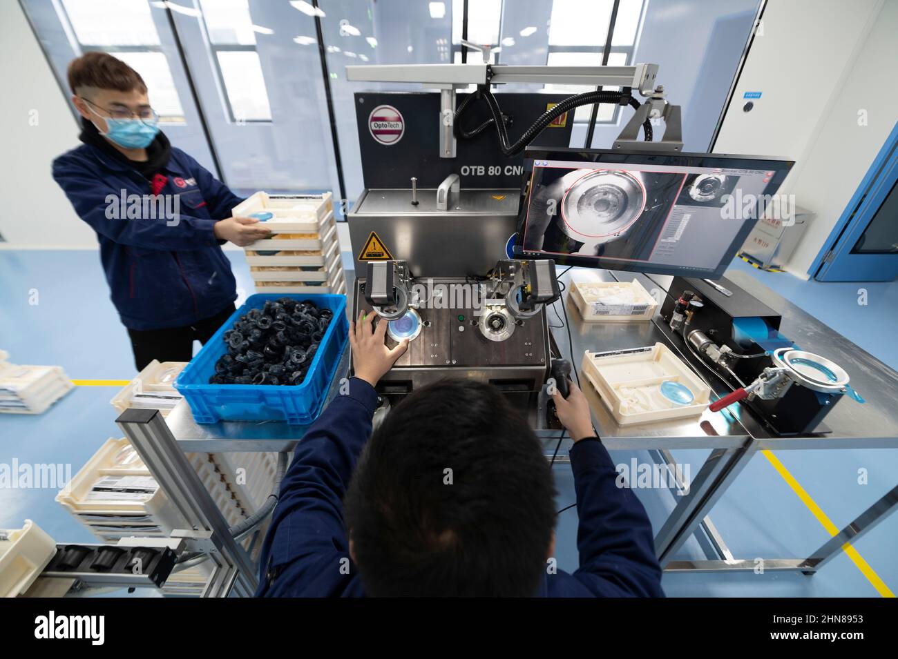 DANYANG, CHINA - FEBRUARY 15, 2022 - A technician makes optical lenses at a dust-free workshop in Danyang, Jiangsu Province, China, February 15, 2022. Stock Photo