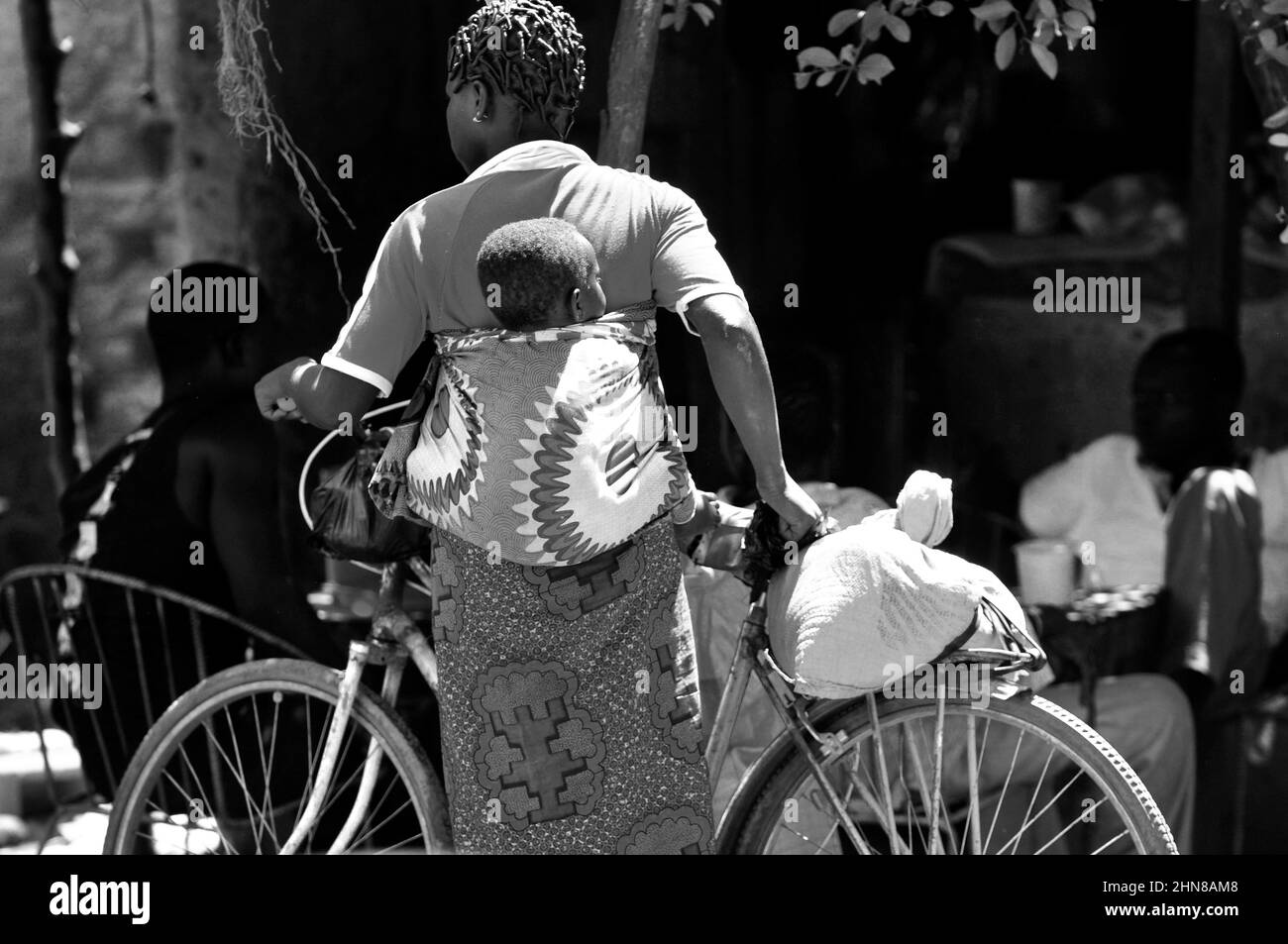 A Burkinabe woman carrying her baby on her back at a local market in central Burkina Faso. Stock Photo