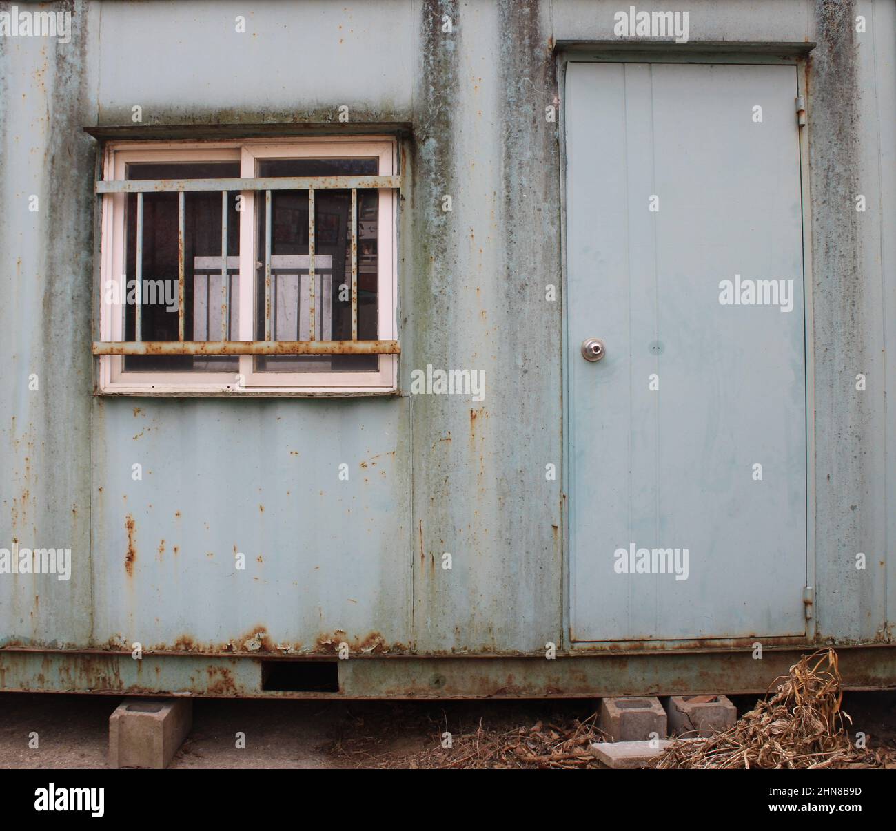 Weathered green shipping container office near construction site Stock Photo