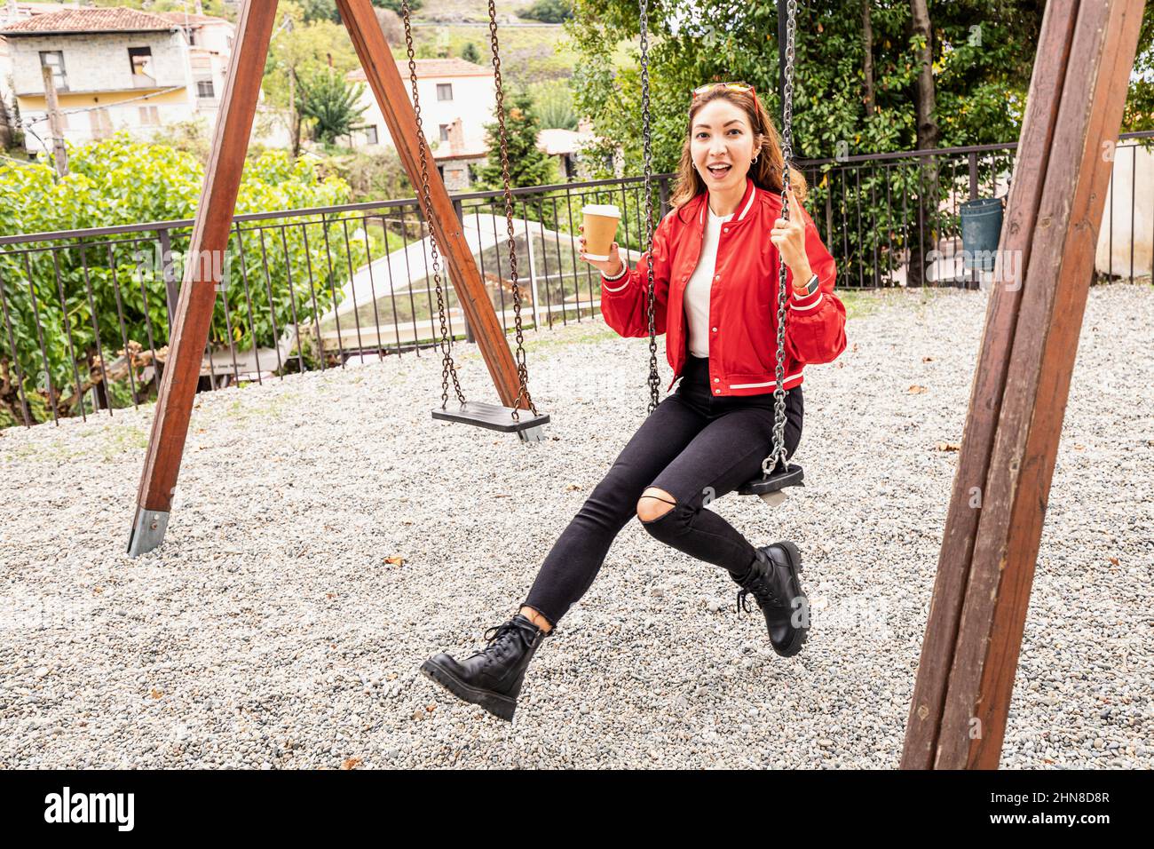 An adult woman on a swing in a city park. Stock Photo