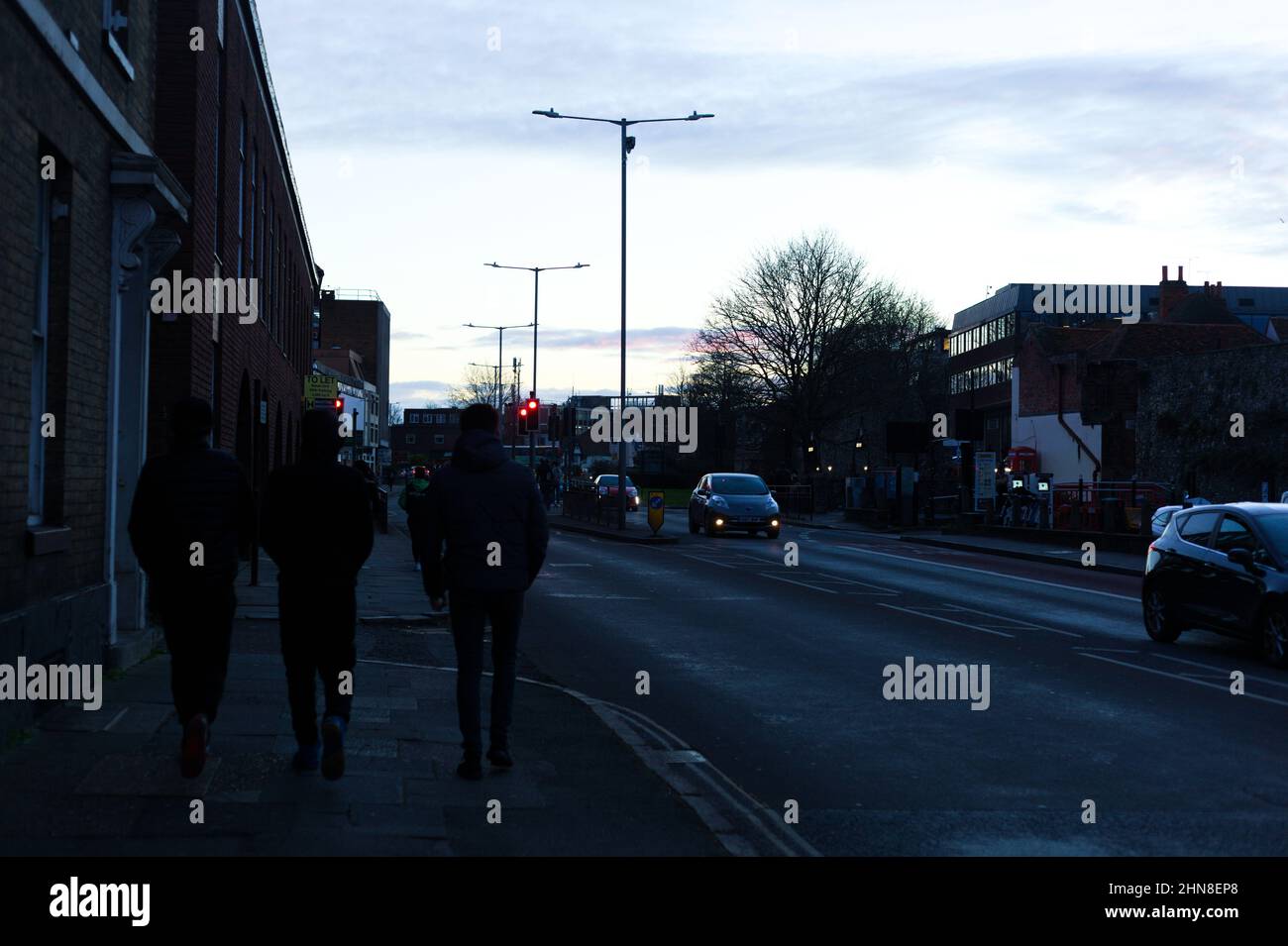 Rear view of three male youths walking alongside A28 Broad Street