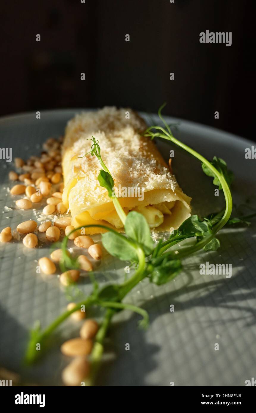 Omelette with green pea sprouts and pine nuts, dramatic sunlight Stock Photo
