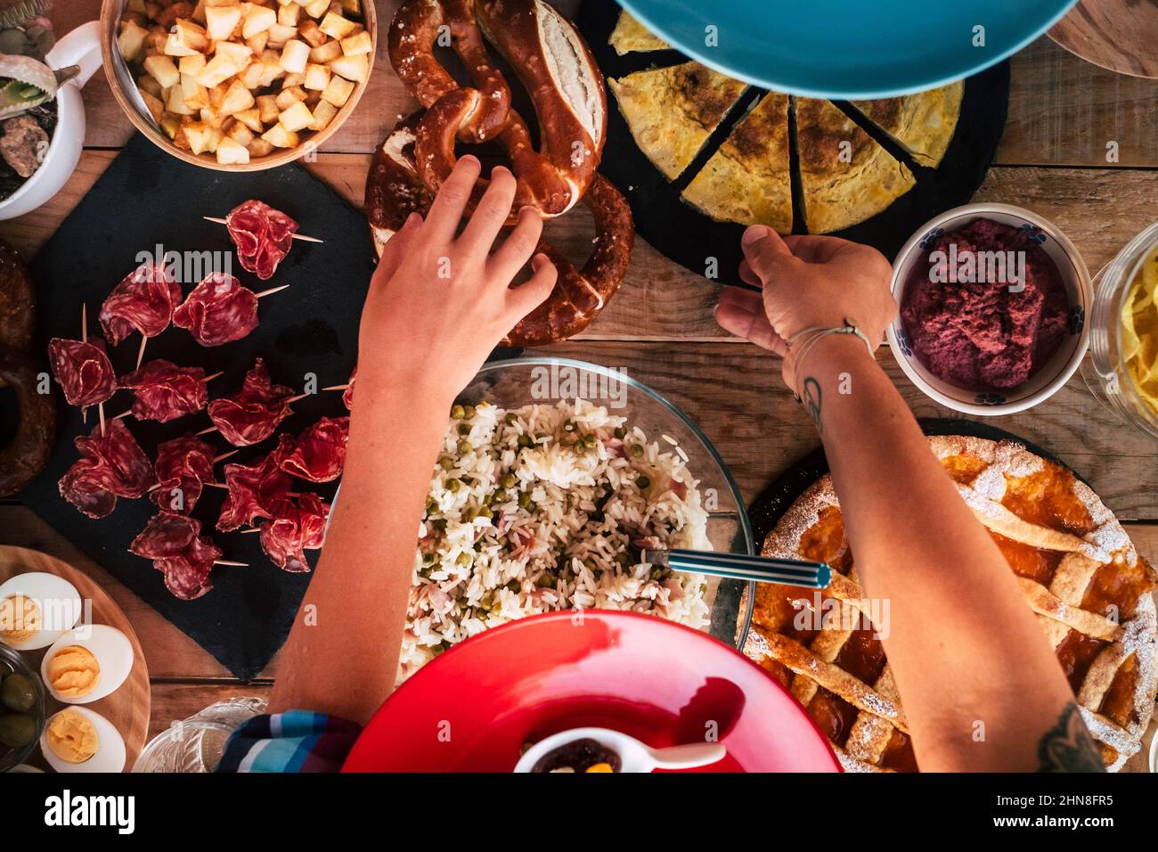 Above top view of hands people taking food from the table. People in