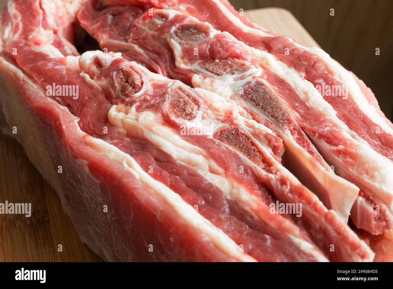 Large pieces of butchered beef with bones on the table close-up Stock Photo