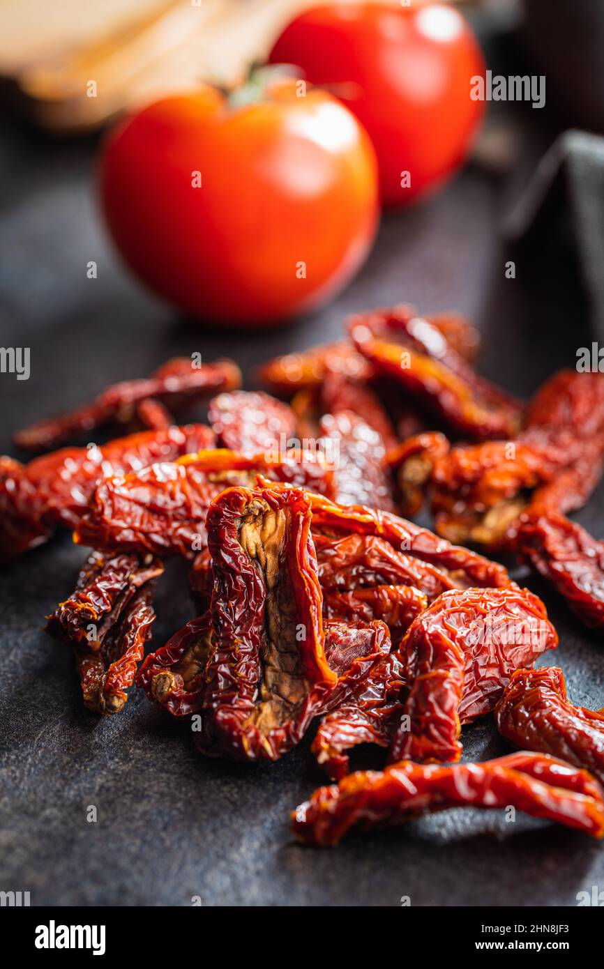 Sun dried tomatoes on a black table. Stock Photo