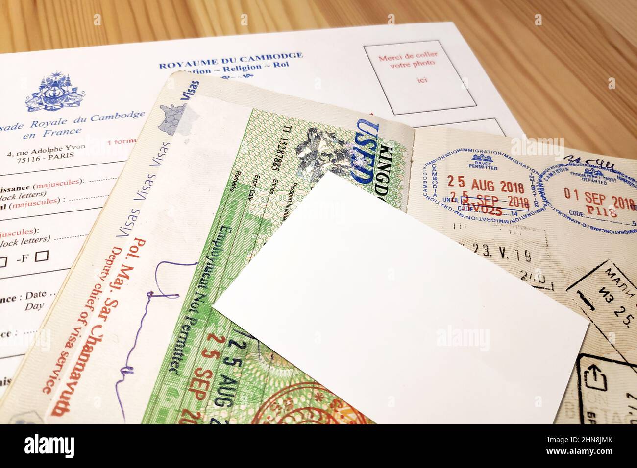 Opened French passport on the top of an application form for a Cambodian tourist visa. Stock Photo