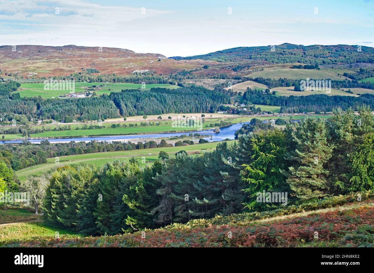 Looking over over a forestry plantation to the flat River Tay valley, and to the farmland, moors, forestry, and hills rising on the opposite bank. Stock Photo