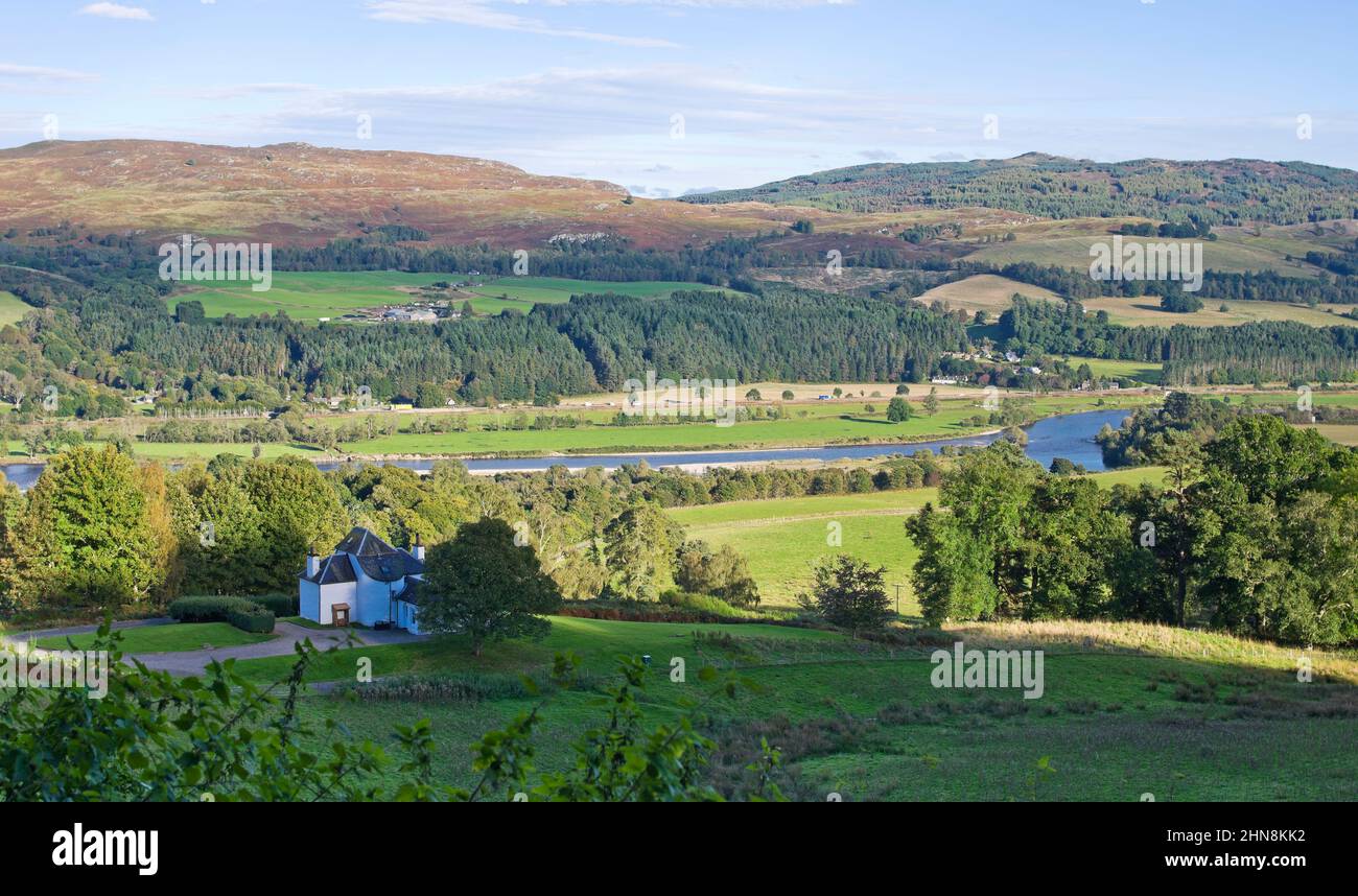 Picturesque white-painted cottage overlooking the River Tay, with the hamlet of Guay nestled into the base of the hillside on the opposite bank. Stock Photo