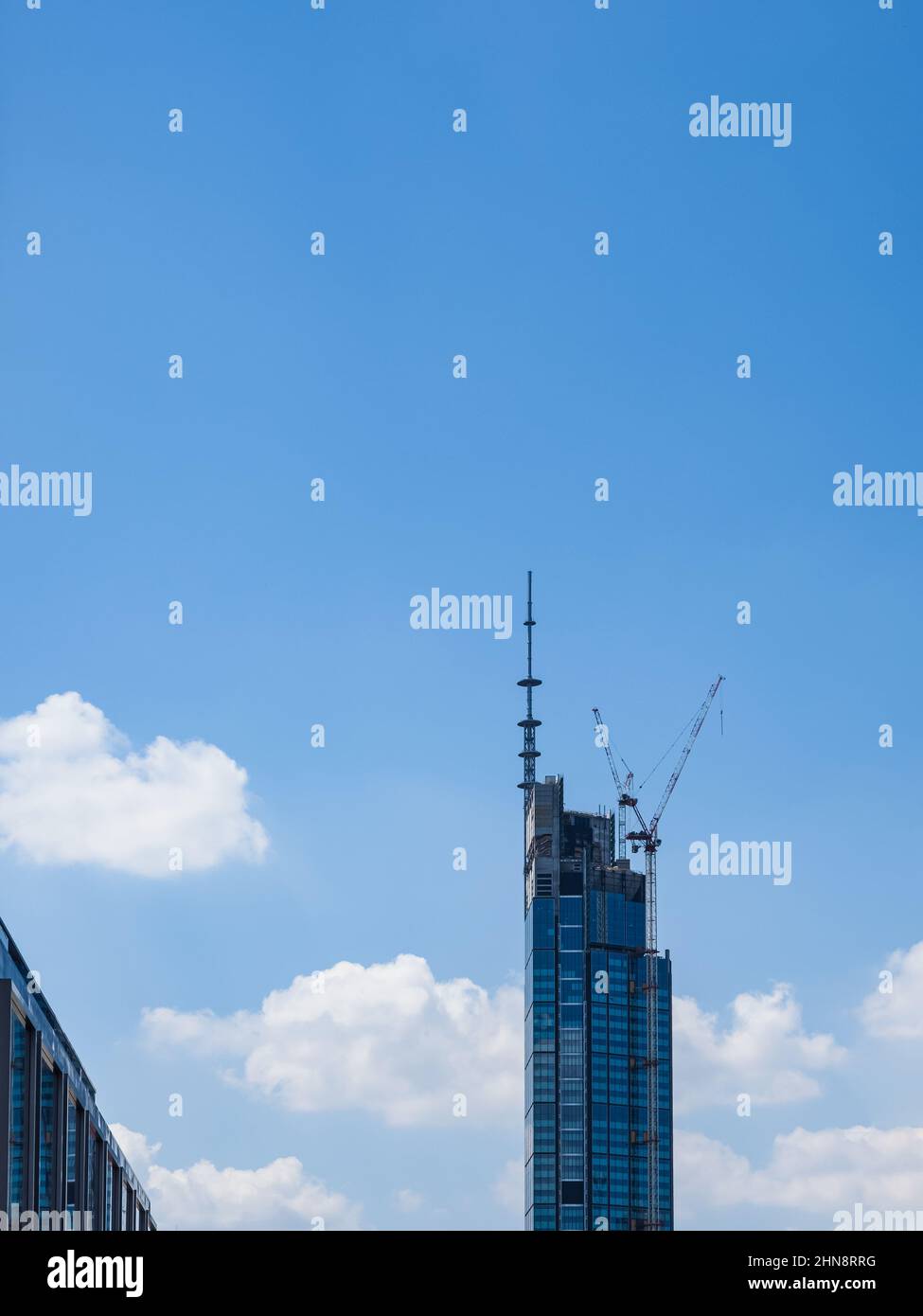 building of a modern skyscraper, front view over blue sky background Stock Photo