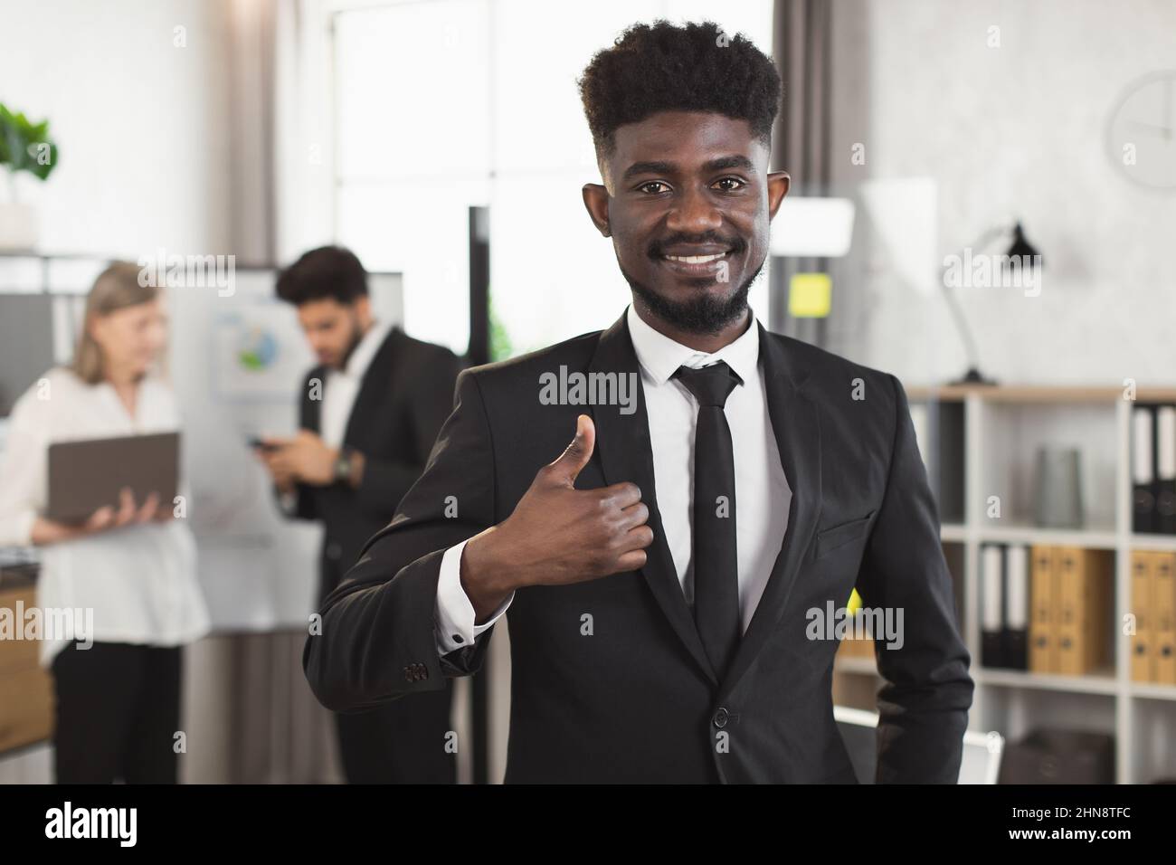 Successful african businessman smiling on camera while his ...