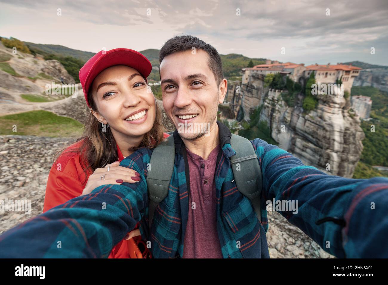 Happy traveler girl taking selfie photos while standing on top of a