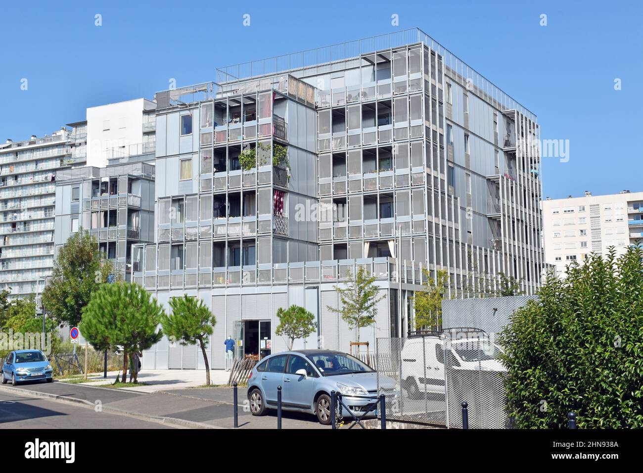 Five floors of high-tech residential apartments above ground floor, almost entirely glass and metal, sunscreening grills, recessed balconies, Stock Photo