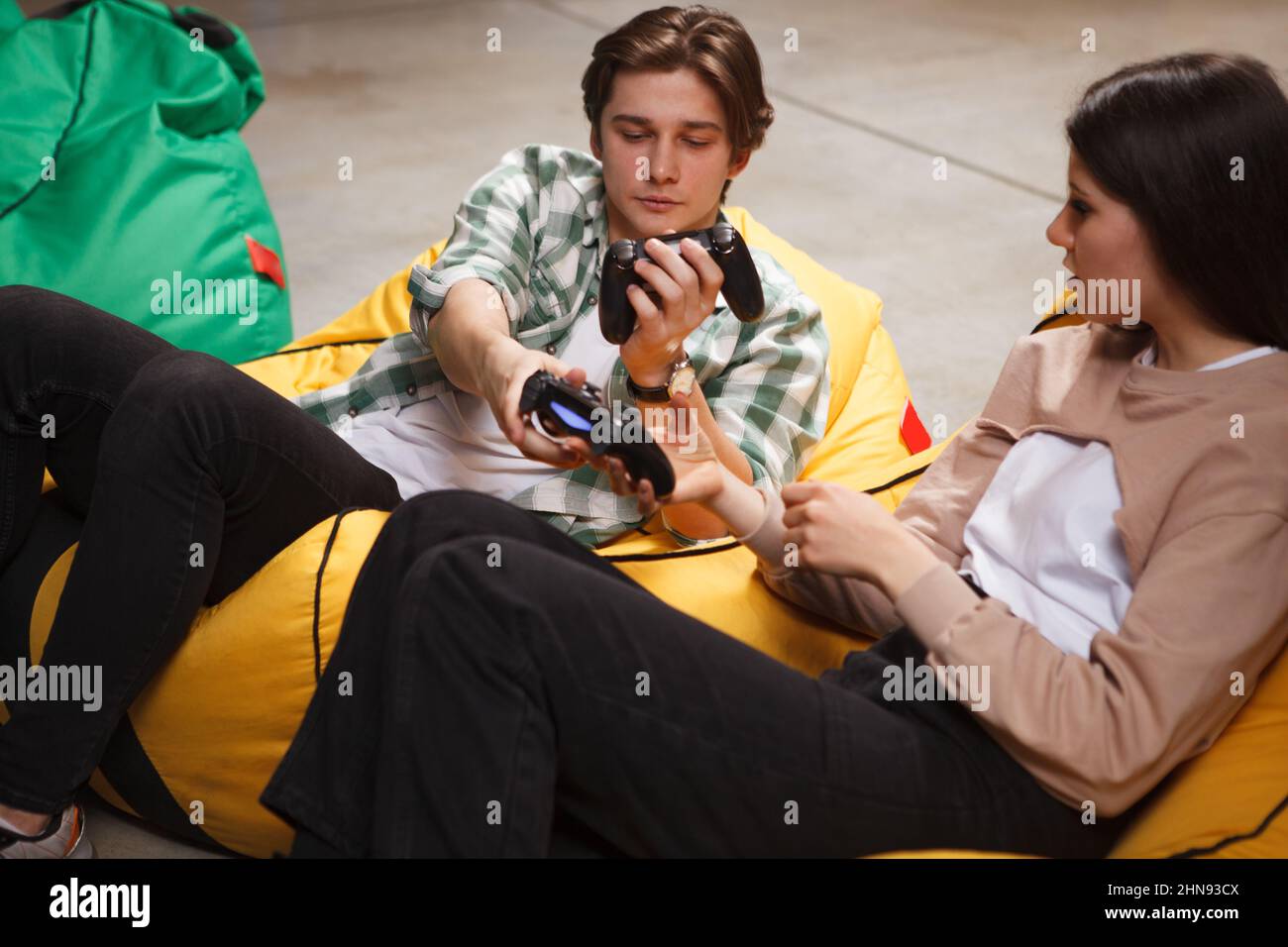 Handsome young man teaching his girlfriend playing video games Stock Photo