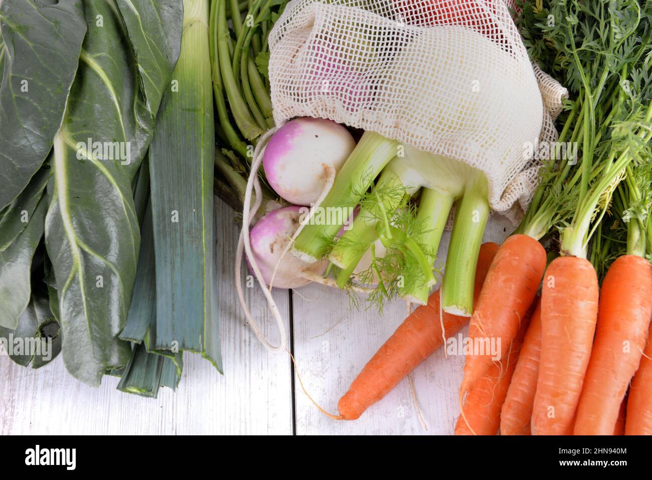 fresh vegetables in a bag among other fresh vegetables on a white table