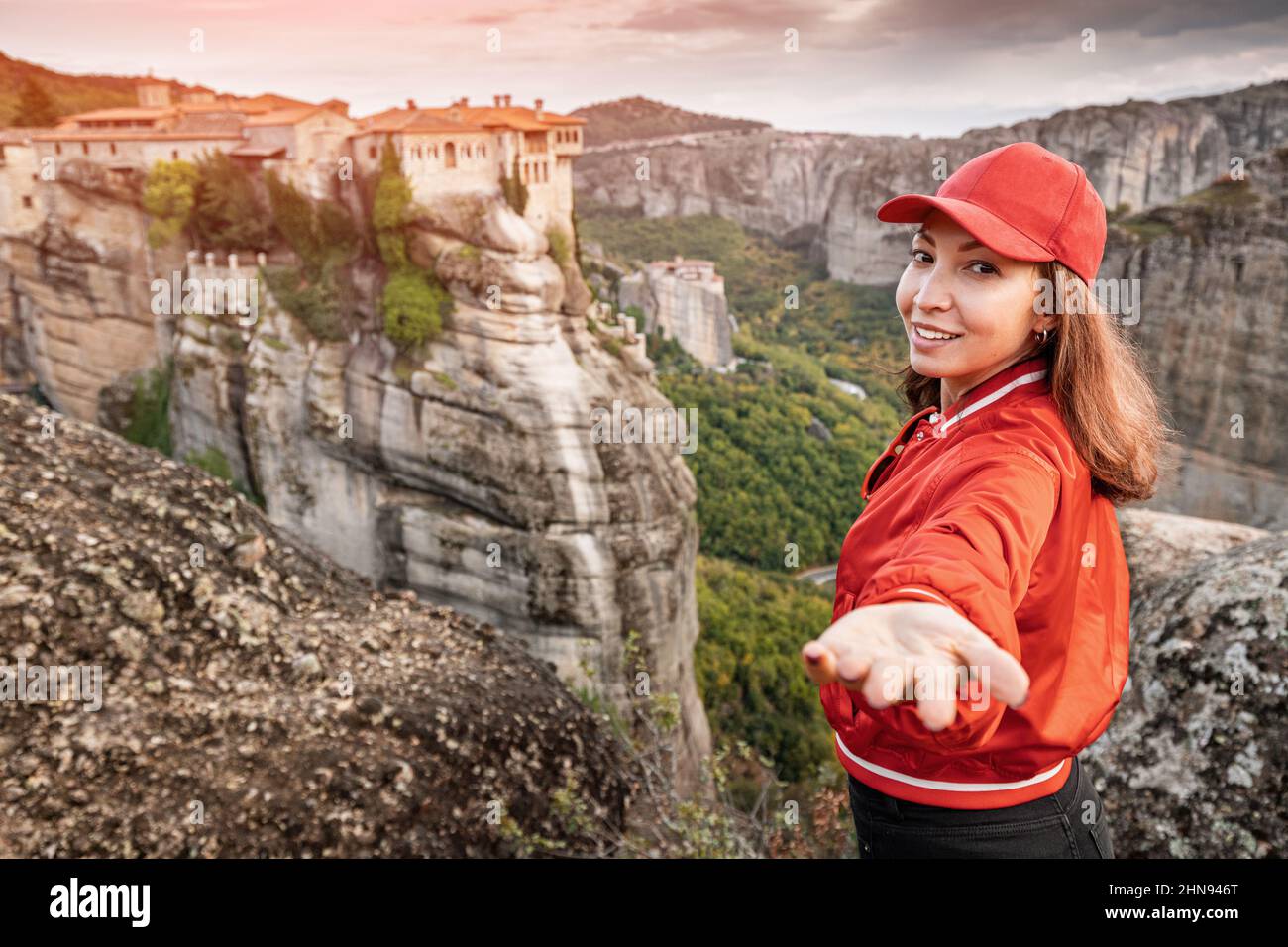 Happy young girl tourist making follow me pose in front of the famous ...