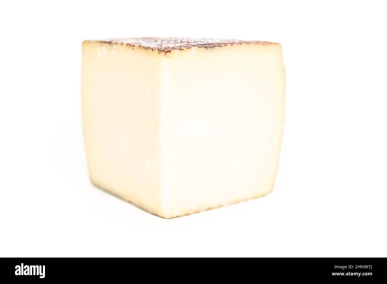 Large slice of aged Manchego cheese on a white background Stock Photo ...