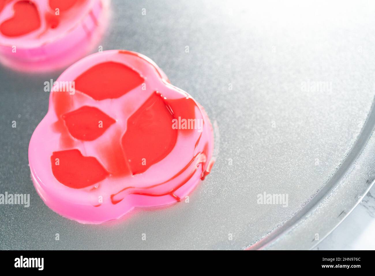 Making hear and kiss shaped chocolate molds with red candy melts Stock