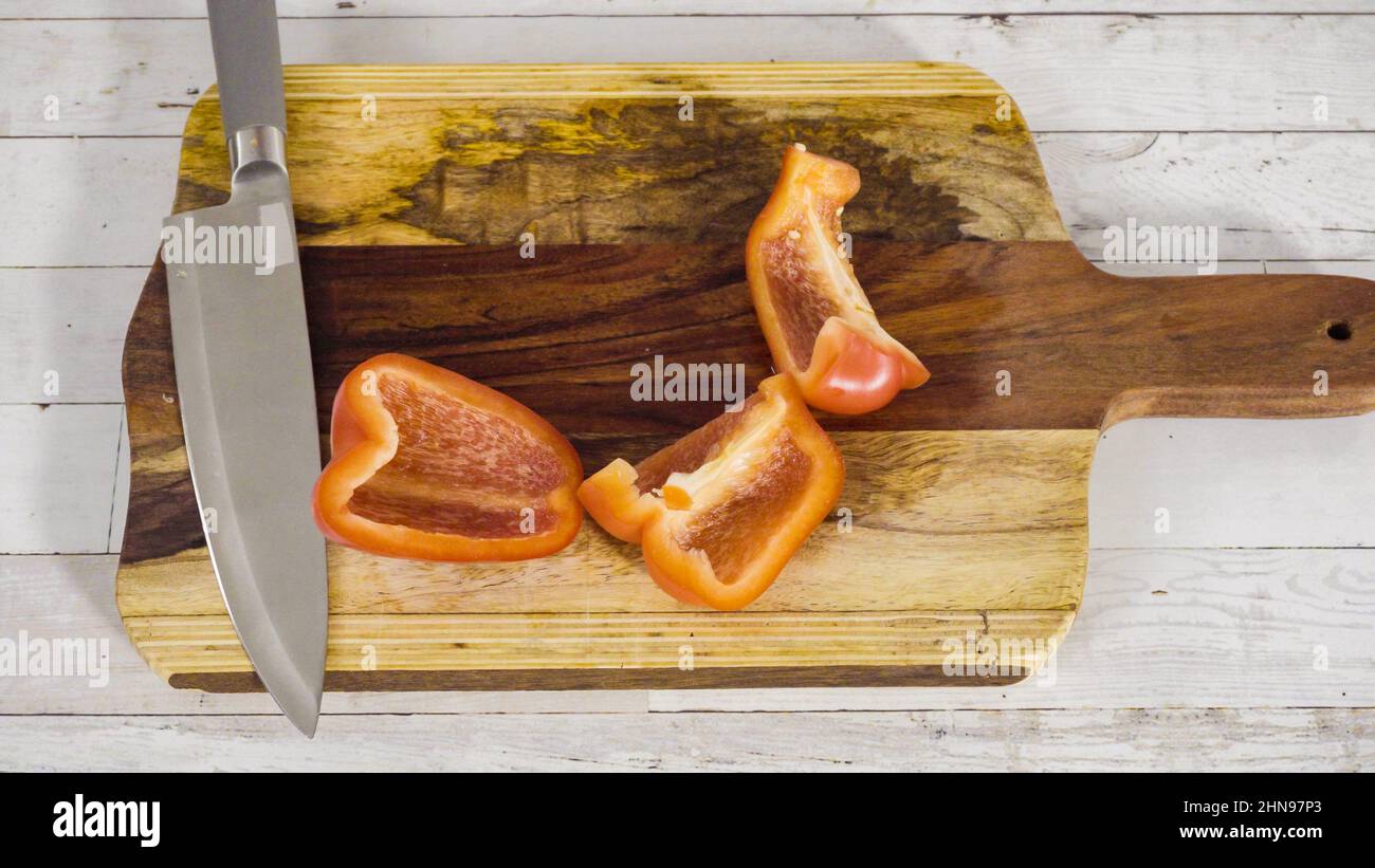 Mincing organic red bell peppers on a wood cutting board Stock Photo ...