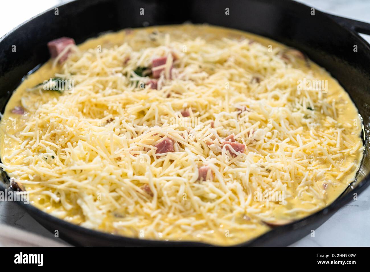 Preparing spinach and ham frittata in cast iron skillet Stock Photo Alamy