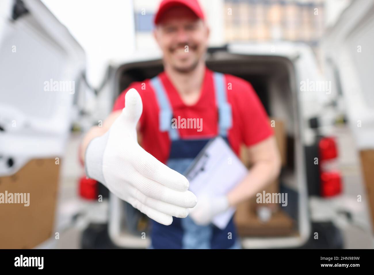 Grocery delivery courier man in red uniform and medical gloves