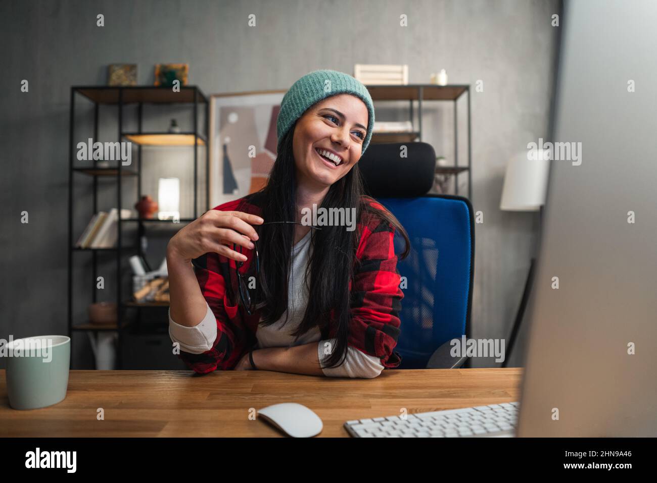 Happy female video editor works indoors in creative office studio. Stock Photo
