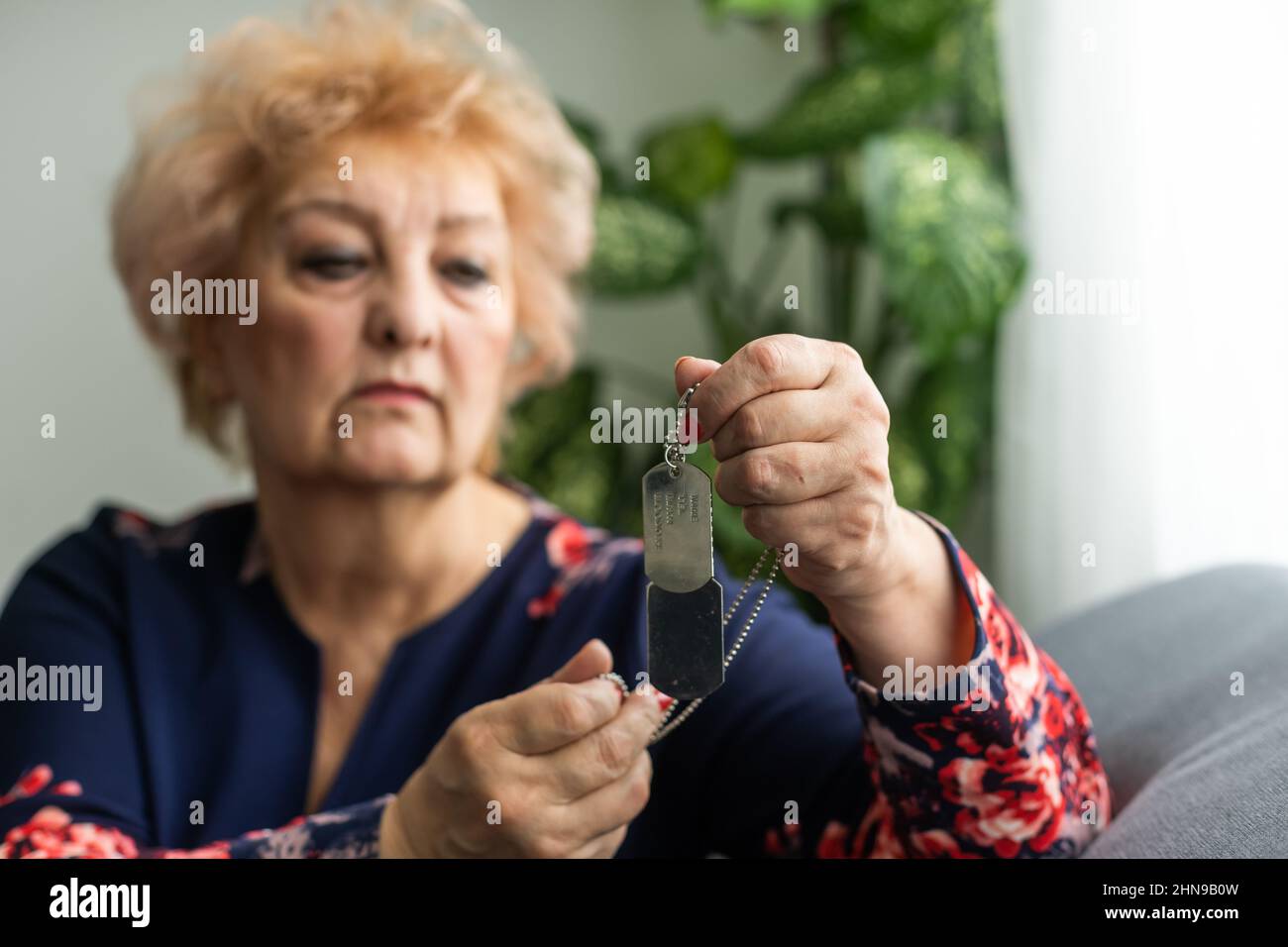 elderly woman with a military dog tag Stock Photo