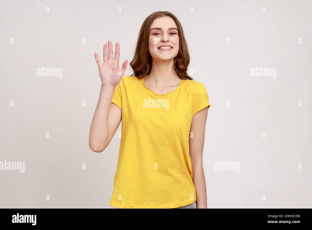 Hello. Portrait of charming teenager girl with brown hair, wearing