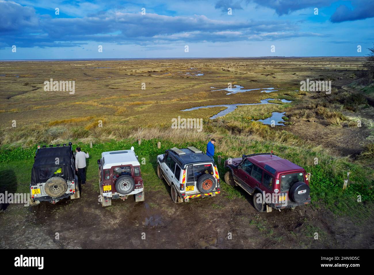 Land Rovers overlooking the salt marshes at Stiffkey. Norfolk, England. Stock Photo