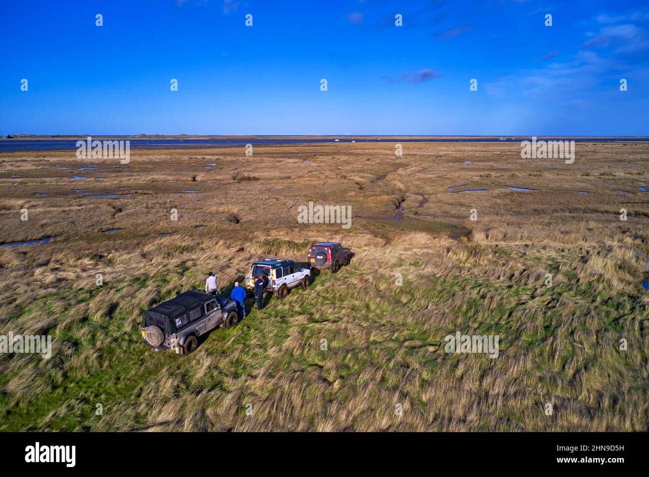 Land Rovers stop where the byway ends at the edge of the salt marshes. Morston Greens, Norfolk, England. Stock Photo